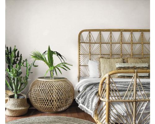 Sovrum i bohemisk stil med bambusäng, sidobord och krukväxter