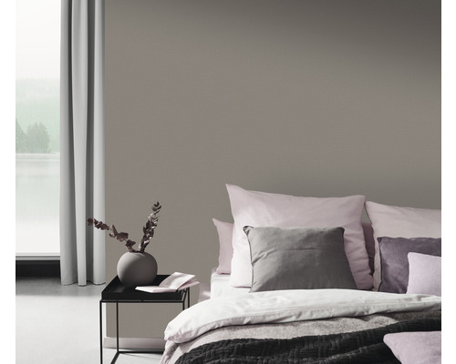 Sovrum med mönstrad tapet, säng och sängbord