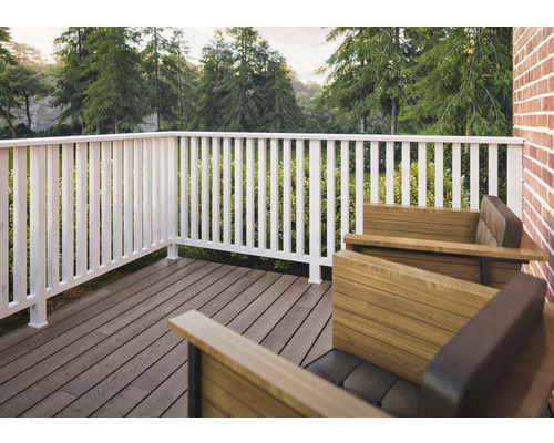 Uteplats med trämöbler och vit räcke med utsikt över grönt landskap