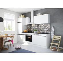 Ljust kök med vita skåp, matbord och barnstol