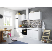 Ljust kök med vita skåp, matbord och barnstol