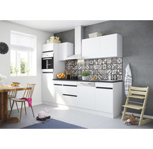 Ljust kök med vita skåp, matbord och barnstol