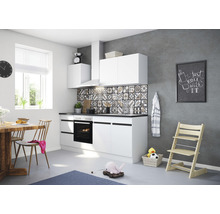 Ljust kök med vita skåp, matbord och barnstol