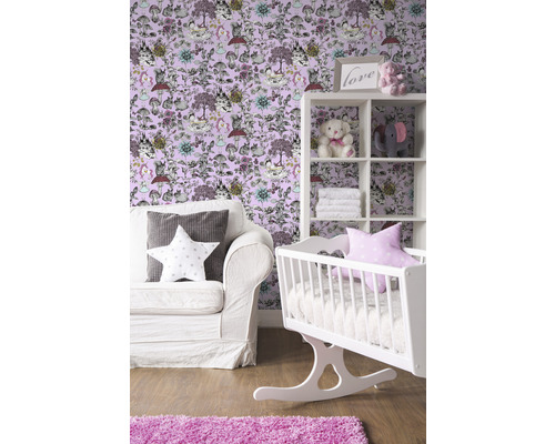 Barnrum med vit vagga, hylla och soffa framför en tapet med djurmotiv