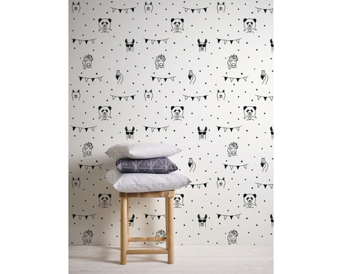 Tapet med djurmotiv och prickigt mönster på ljus bakgrund, plus en pall med kuddar