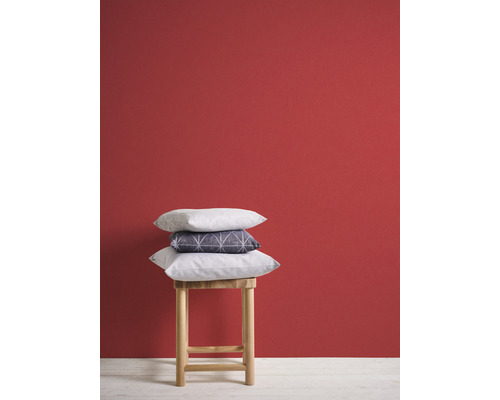 Dekorativa kuddar på en träpall framför en vägg