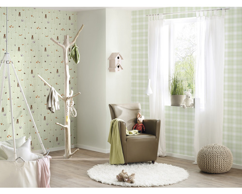 Ljust designat rum med barntapet, fåtölj, klädhängare och hängande korg