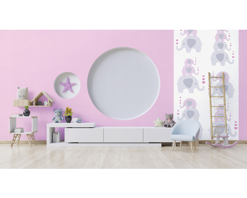Ljust barnrum med rosa vägg, vitt skåp, stol och elefanttapet