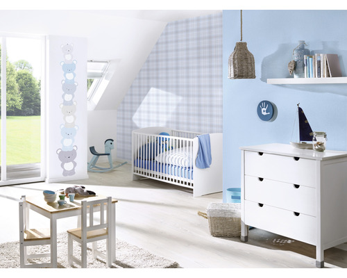 Ett barnrum med en barnsäng, en byrå, ett bord och stolar.