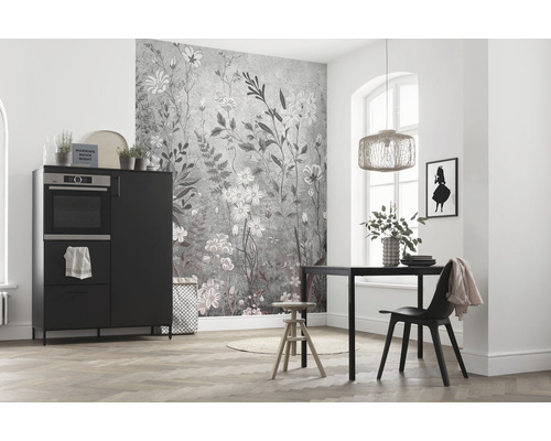 Ljust rum med köksbord, stol, skåp med ugn och väggtapet med blommönster.