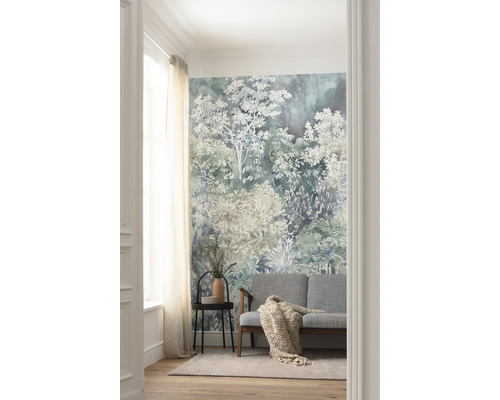 Vardagsrum med en skogstapet, en soffa, ett sidobord och en matta.