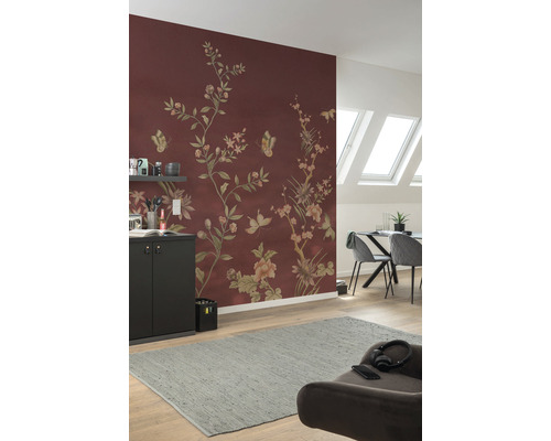Vardagsrum med blommig tapet i rödbrunt, matbord, stolar och grå matta.