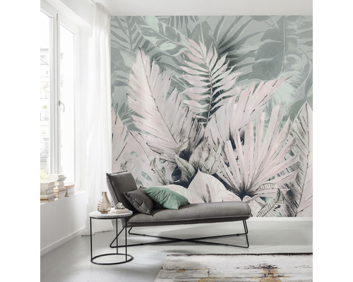 Ljust vardagsrum med blommig fototapet, soffa och sidobord.