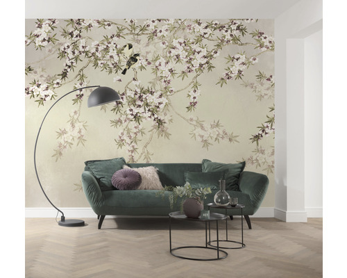 Vardagsrum med blommig tapet, soffa, golvlampa och sidobord