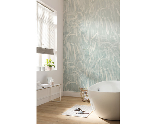 Badrum med fristående badkar, mönstrad tapet och trägolv