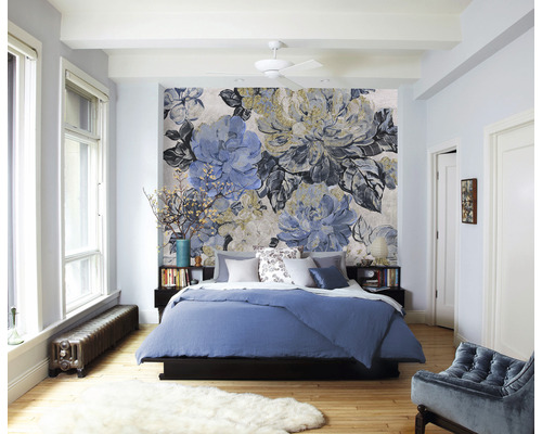 Sovrum med blommig tapet, säng och sängbord.