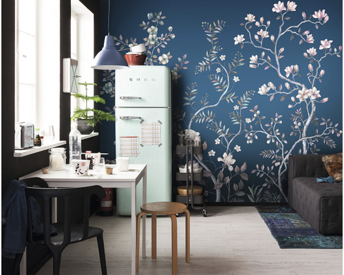 Vardagsrum med kylskåp, matbord och tapet med blommönster