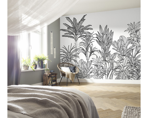 Sovrum med djungeltapet, säng, stol och krukväxter