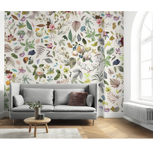 Vardagsrum med soffa och blommig tapet med blad och blommor.