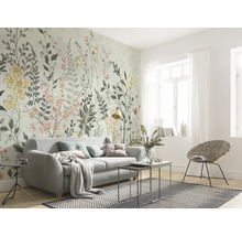 Vardagsrum med blommig fototapet, soffa och rottingfåtölj