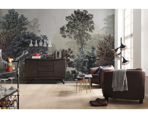 Vardagsrum med en fototapet med skogsmotiv, en skänk och läderfåtöljer.