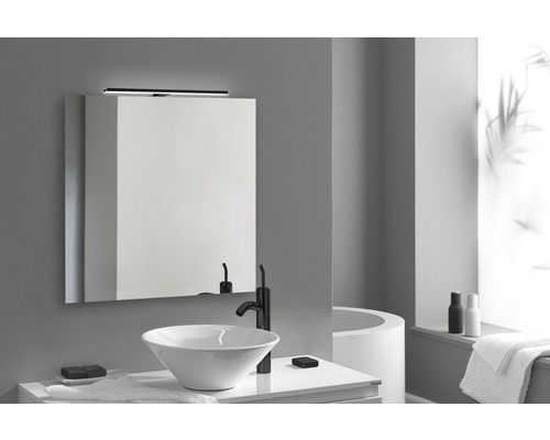 Modernt badrum med tvättställ, handfat, spegelskåp och belysning.