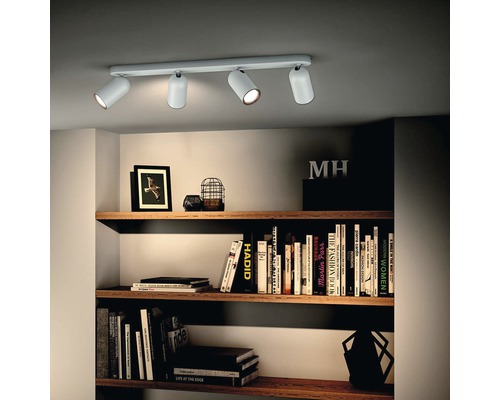 Taklampa med fyra spotlights i vardagsrummet ovanför en bokhylla