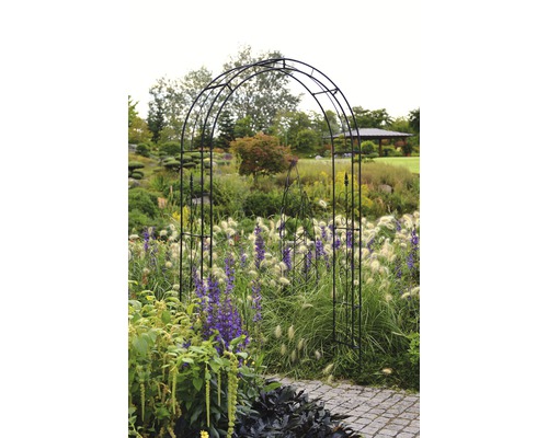 Trädgårdsscen med metallbåge över en stig.