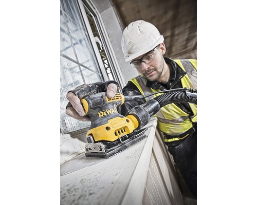 Hantverkare slipar fönsterkarm med en DeWalt planslipmaskin