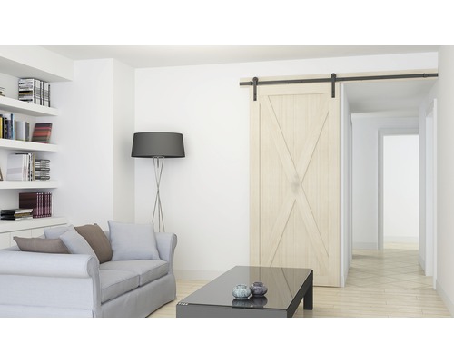 Vardagsrum med skjutdörr i ladugårdsstil, soffa, bord och bokhylla.