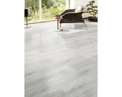 Ljust vardagsrum med laminatgolv, fåtölj och TV.