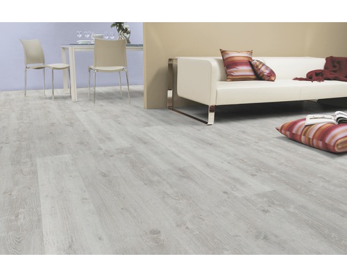 Ljust laminatgolv i ett vardagsrum med soffa och matplats.