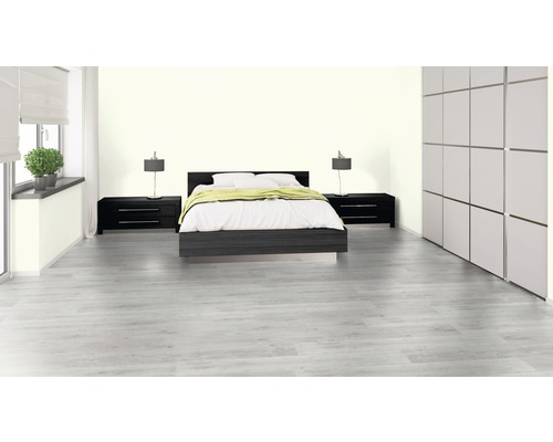 Ljust sovrum med säng, sängbord och garderob