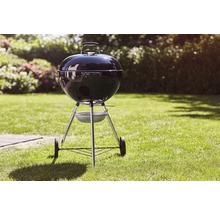 Klotgrill på en gräsmatta i trädgården