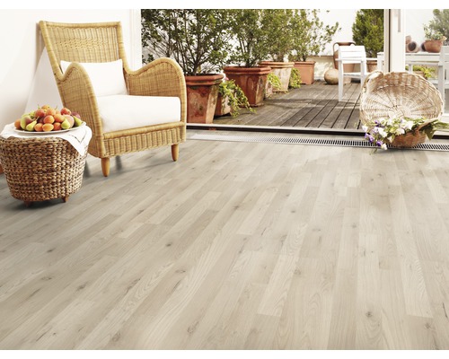 Ljust trägolv med rottingfåtölj, frukt och blommor på terrassen