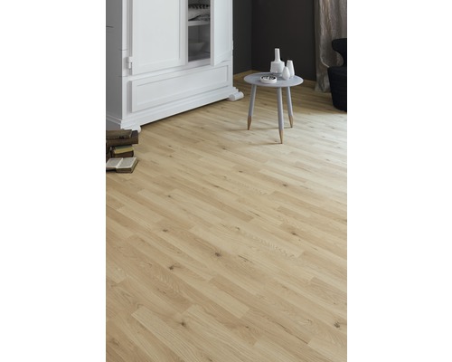 Ljust rum med laminatgolv i trälook, skåp och litet bord