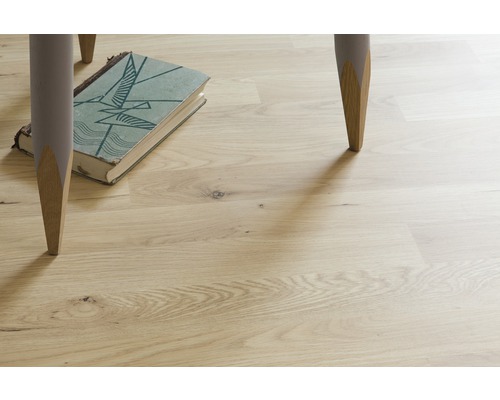 Ljust trägolv med bordsben och bok