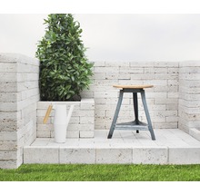 Scen med en växt, en vattenkanna och en pall på en stenplattform