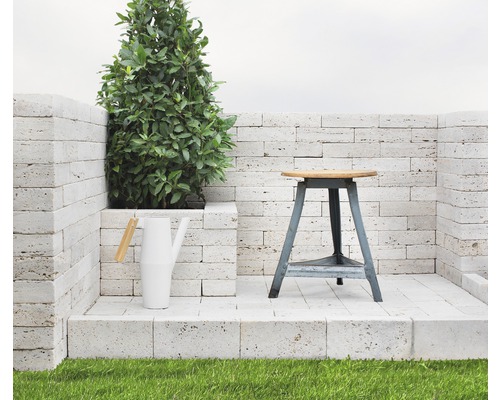 Scen med en växt, en vattenkanna och en pall på en stenplattform