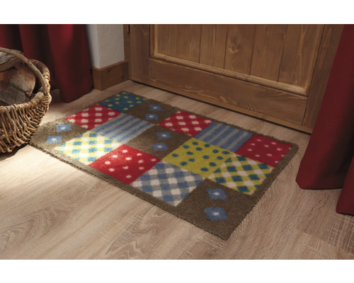 Färgglad dörrmatta med olika mönster framför en dörr.