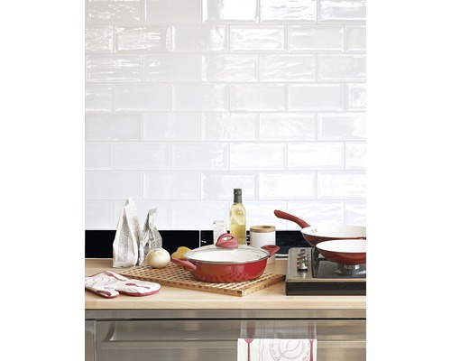 Köksscen med köksredskap, ingredienser och vita kakelplattor