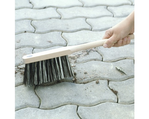 Fogborste med trähandtag rengör gatsten från ogräs