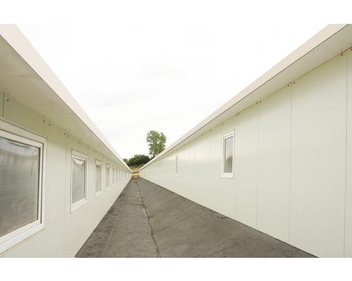 Lång korridor mellan två rader kontorscontainrar med fönster