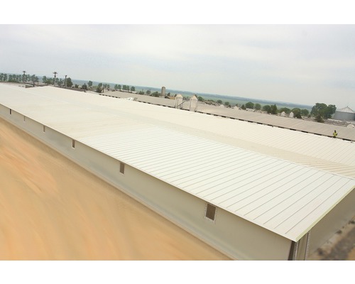 Vy över en lång, låg lagerbyggnad med plåttak