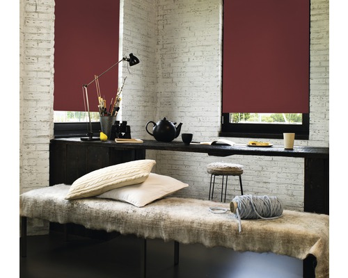 Ljust rum med rullgardiner, bord, lampa, kuddar och dekorativa föremål för en mysig atmosfär