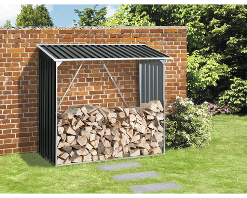 Vedställ i metall med ved mot en tegelvägg