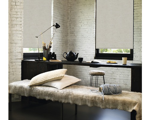 Inredning med rullgardiner framför fönster, bord, bänk och tillbehör i ett ljust rum.