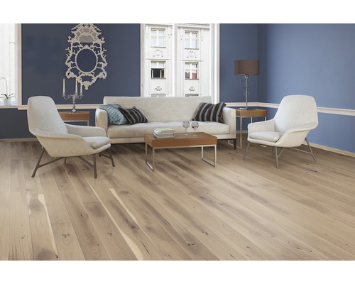 Ljust vardagsrum med trägolv, soffa och fåtöljer för en mysig atmosfär.