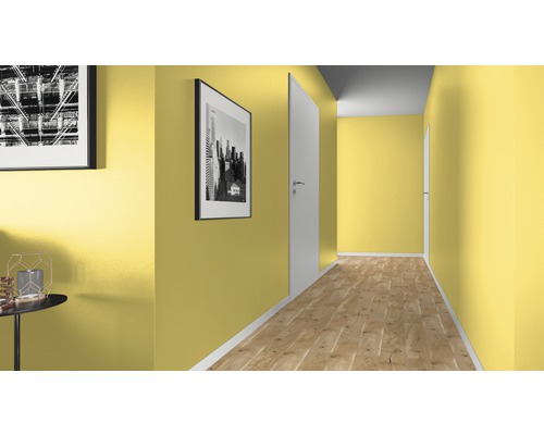 Hall med gula väggar, trägolv och vita dörrar.