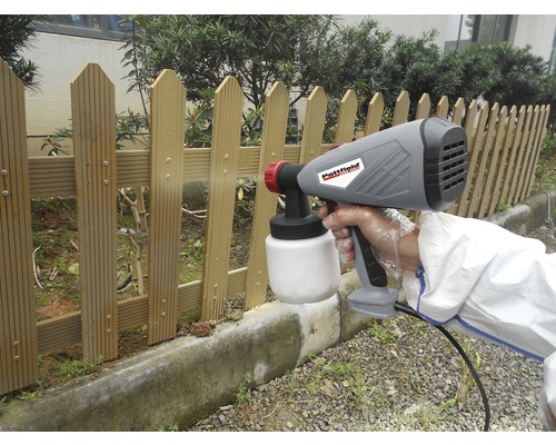 Färgspraysystem som används för att måla ett trästaket